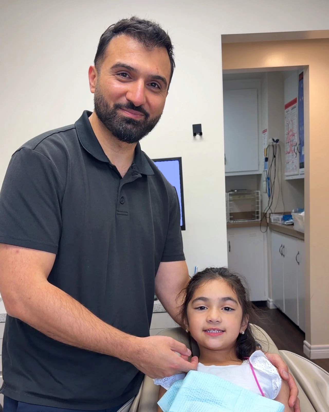 Dr. Sohrab Ansari with a young patient smiling in the chair at Serenity Family Dentistry in Royal Oak